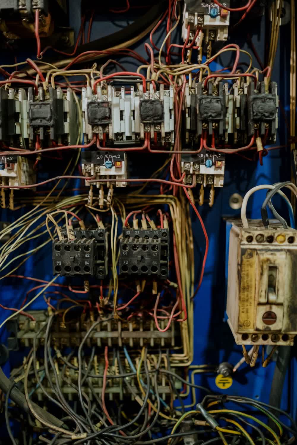 Ancienne armoire électrique aux contacteurs encrassés et aux fils emmêlés, avant sa mise aux normes