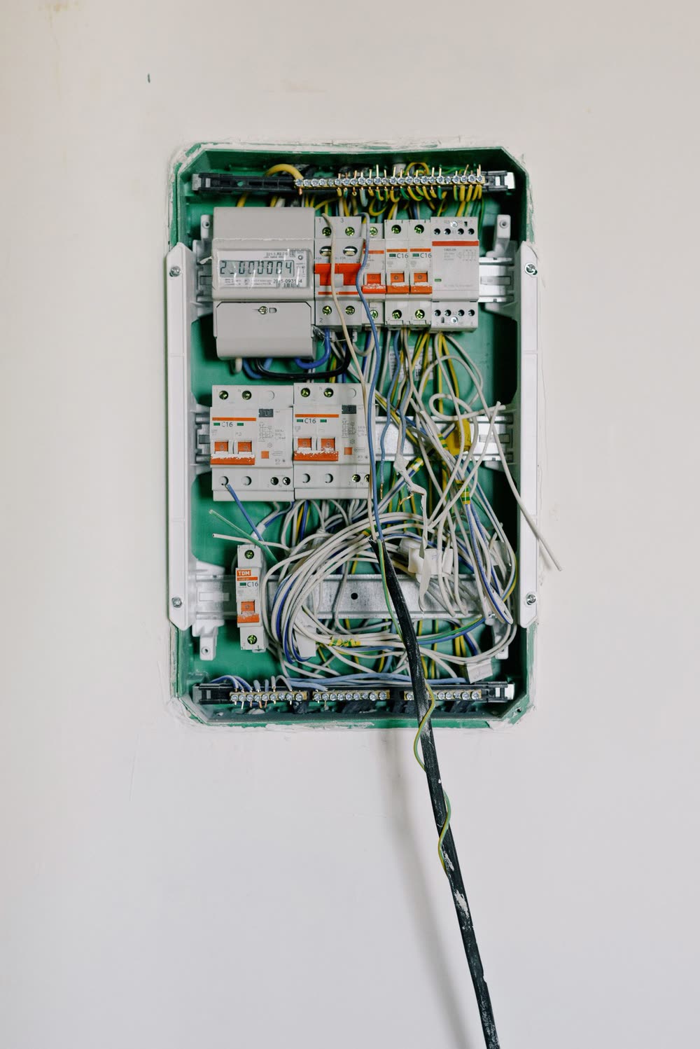 Tableau électrique en cours de câblage, disjoncteurs neufs posés sur leurs rails